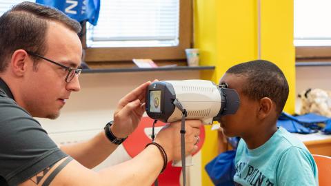 Augenoptiker untersucht ein Kind