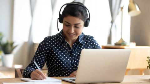 Mädchen mit Headset lernt am Laptop online